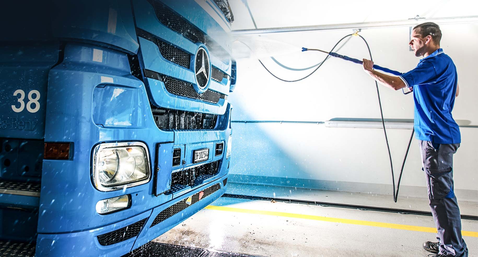 Chauffeur reinigt Fahrzeug in LKW-Waschanlage